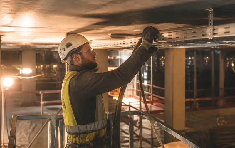 משיכת כבלי חשמל בבניין בשלב שלד בשקיעה
